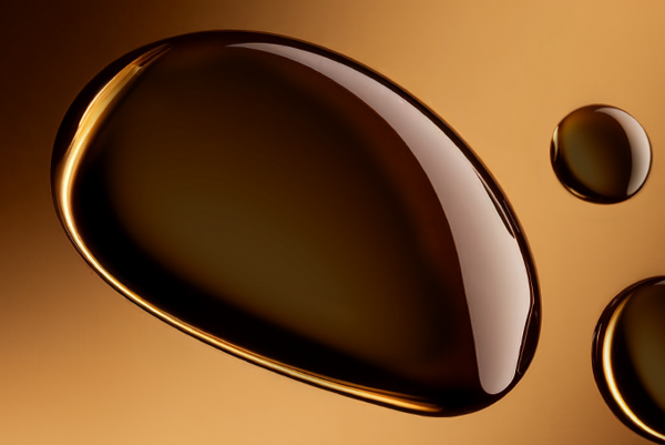 STRIOVER® – dermocosmetic active for reducing stretch marks and firming the skin. Drops of dark serum on a brown background.